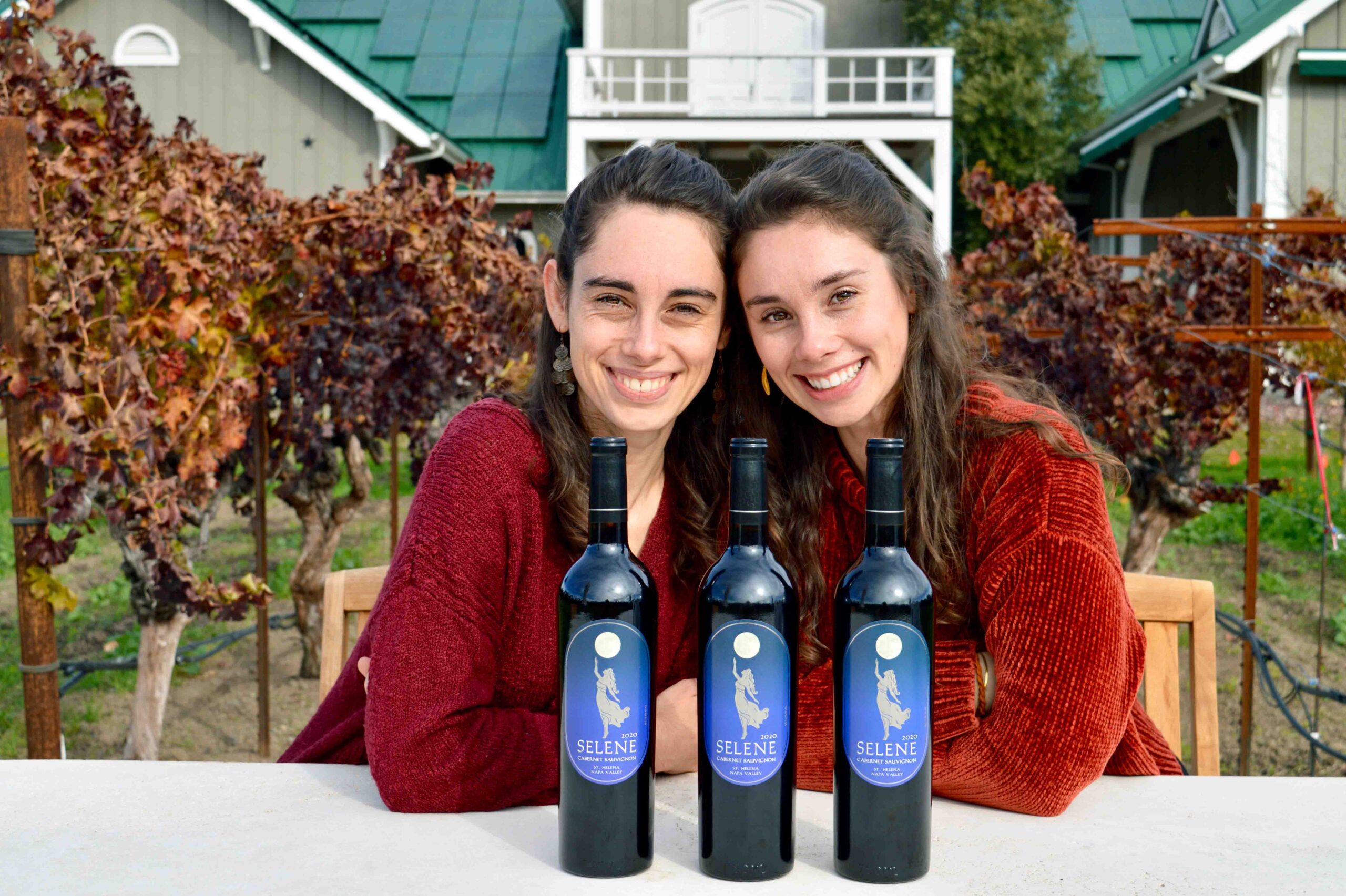 Rose and Grace Corison Martin presenting three bottles of the 2020 Selene Cabernet Sauvignon.